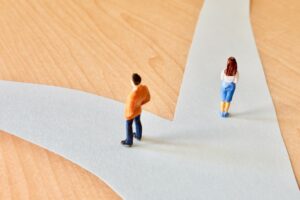 分かれ道で違う道を進む男性と女性